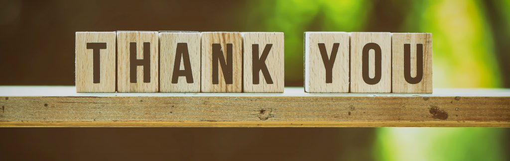 Scrabble letters on a block saying thank you